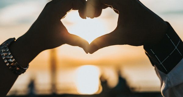 Heart hands cradling a pregnant belly